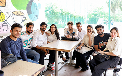 Finance – Expertise in Financial Management and Analysis A group of students sitting together in the canteen at IMS Noida, engaging in discussions and enjoying their break.