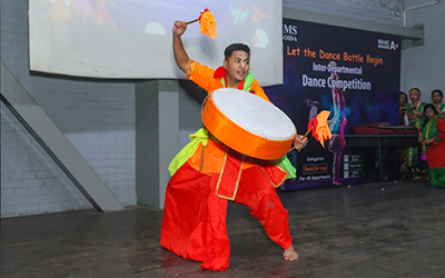 PGDM Student Performing Dance with Drum at Inter-Departmental Dance Competition A student performing a dynamic dance with a drum at the Inter-Departmental Dance Competition at IMS Noida